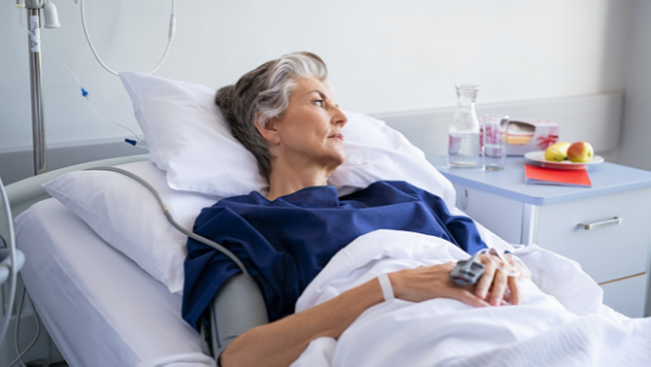 dojrzała kobieta leży na szpitalnym łóżku po operacji na nietrzymanie
 moczu